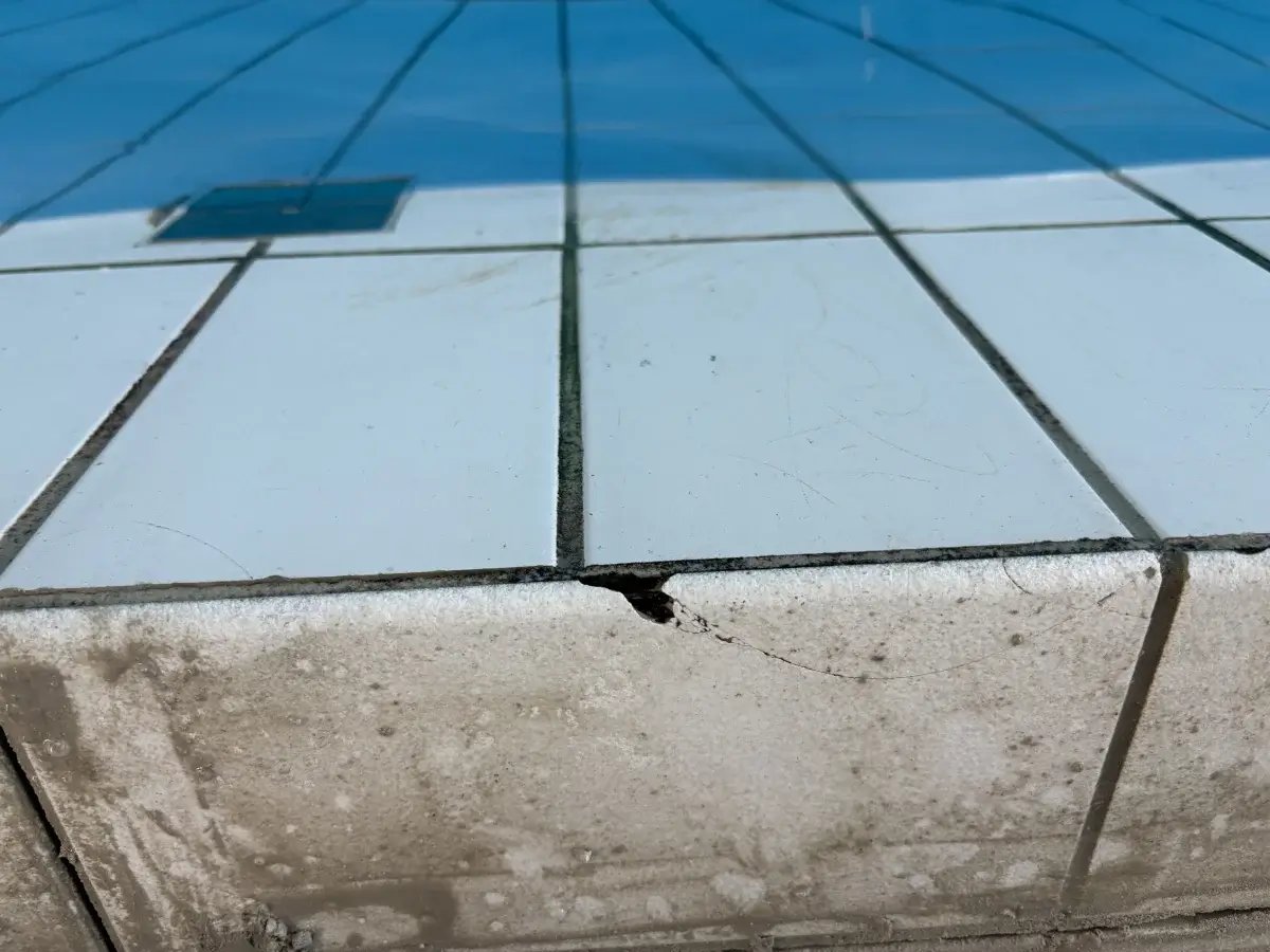 Sprucken keramik vid bassängkant